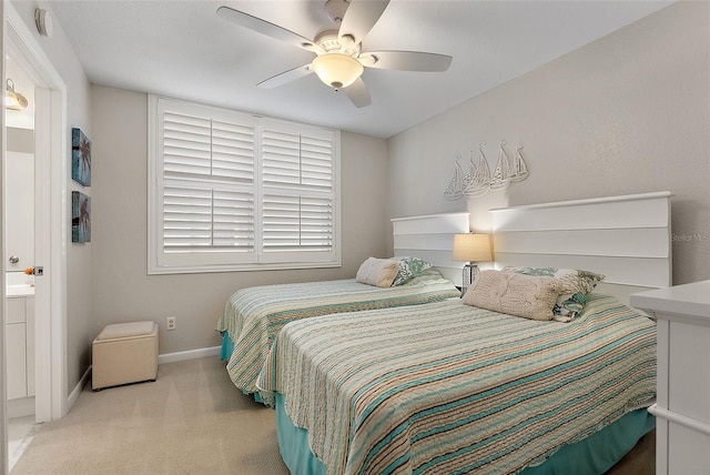 bedroom featuring light carpet, ensuite bath, and ceiling fan