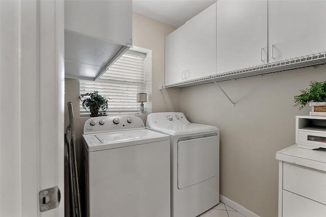 washroom with cabinets, light tile patterned flooring, and washer and clothes dryer