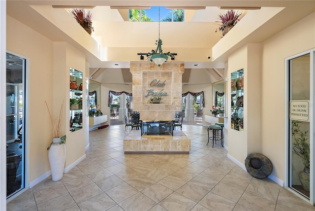 entryway with a tray ceiling and light tile patterned floors