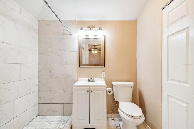 bathroom with a tile shower, vanity, and toilet