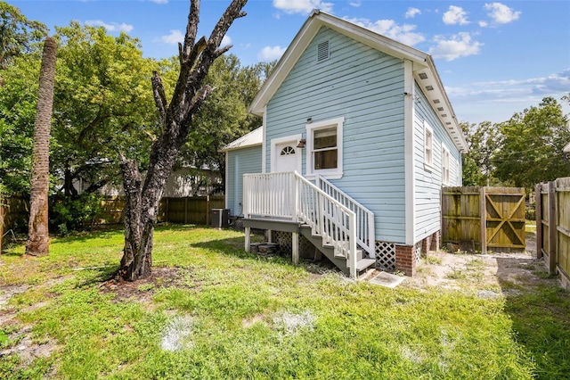 rear view of house with a yard and cooling unit