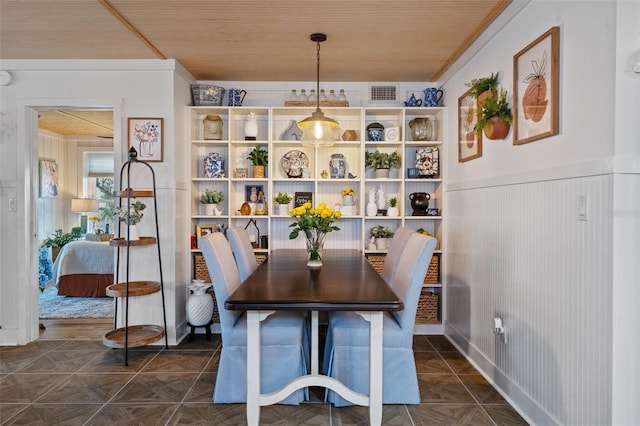 dining area featuring dark tile patterned flooring and wooden ceiling