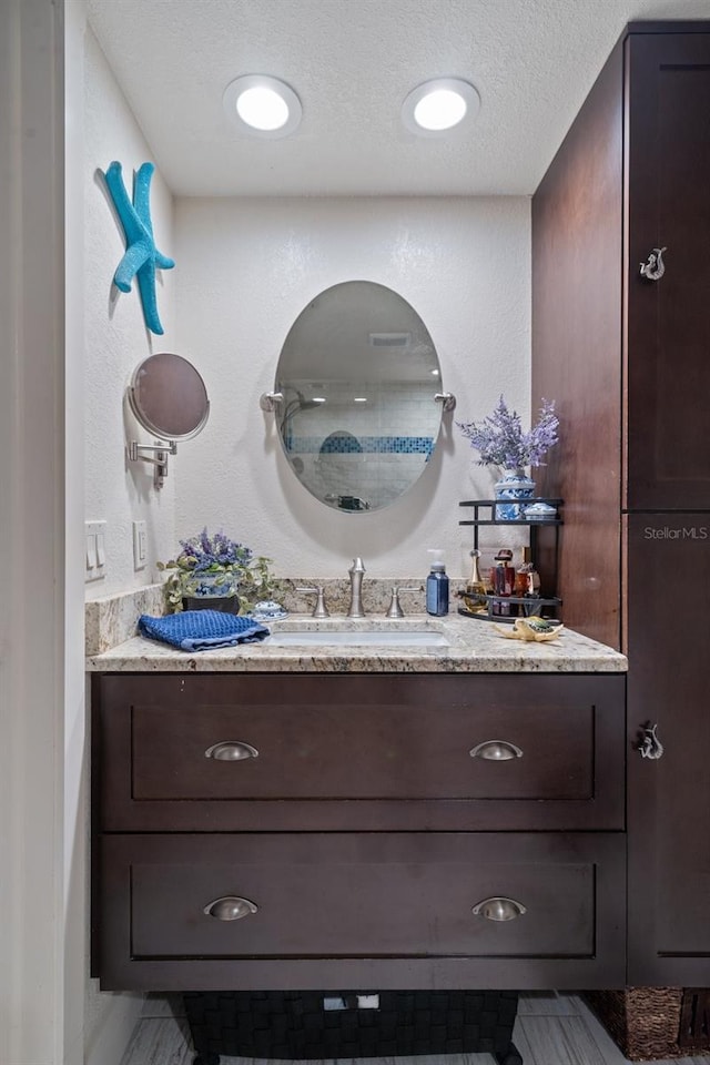 bathroom with a textured ceiling and vanity