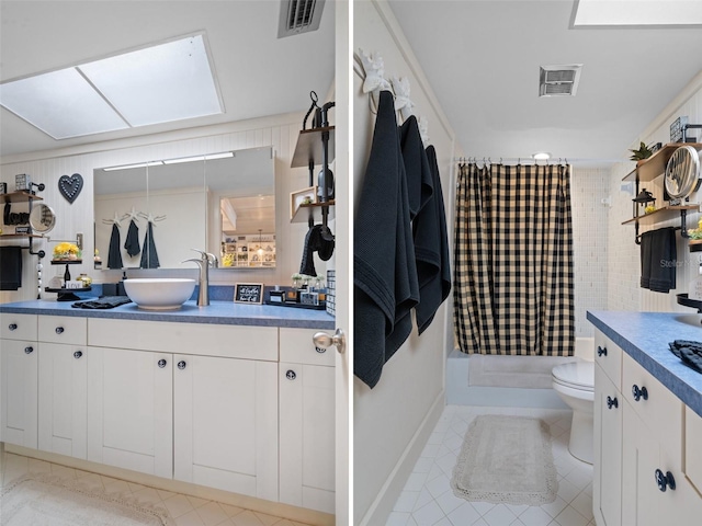 bathroom with toilet, vanity, and curtained shower