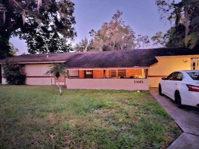 ranch-style home featuring a lawn