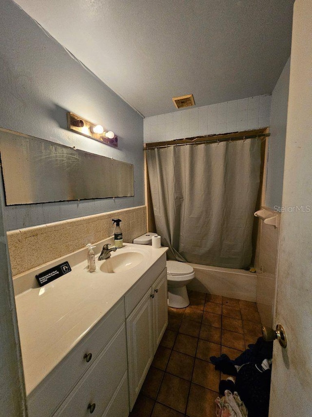 full bathroom featuring toilet, vanity, shower / bathtub combination with curtain, and a textured ceiling