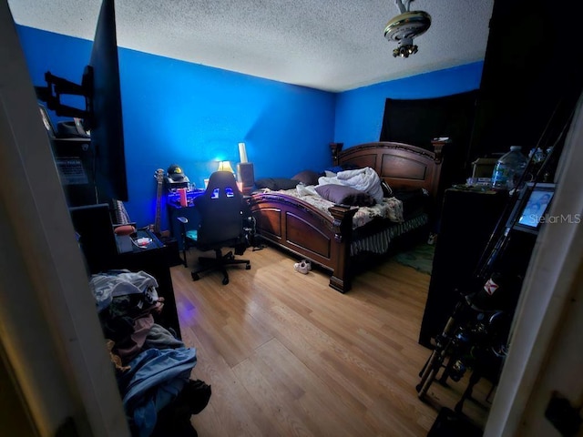 bedroom featuring hardwood / wood-style flooring and a textured ceiling