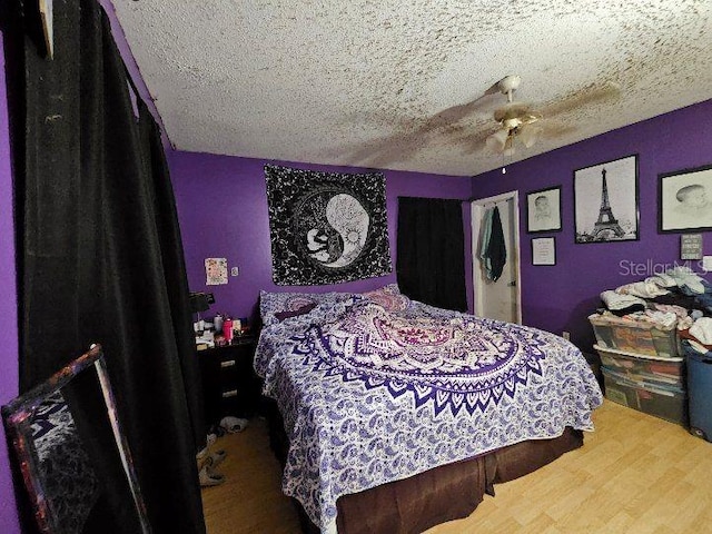 bedroom featuring a textured ceiling, ceiling fan, and hardwood / wood-style flooring