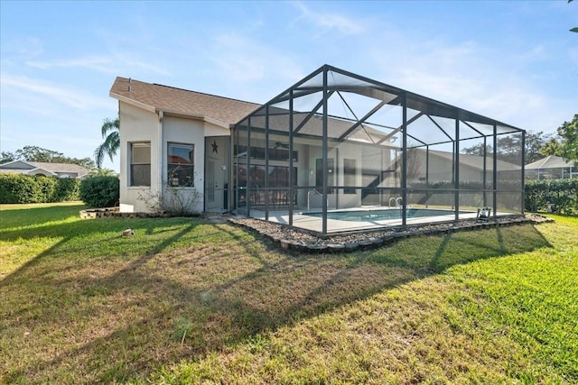 back of house with glass enclosure, a lawn, and a patio