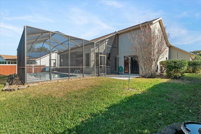 rear view of house with a yard, a patio area, and glass enclosure