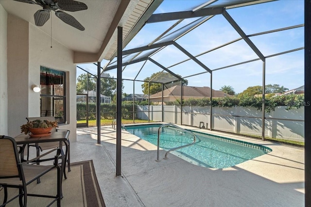 view of pool with glass enclosure, ceiling fan, and a patio