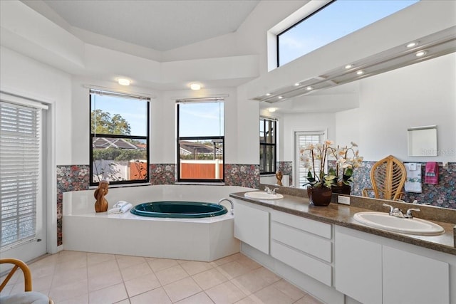 bathroom featuring vanity, a tub, vaulted ceiling, and tile patterned floors