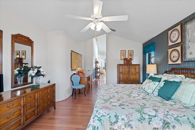 bedroom with ceiling fan, lofted ceiling, and wood-type flooring