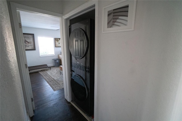 washroom with stacked washer and clothes dryer and dark hardwood / wood-style floors