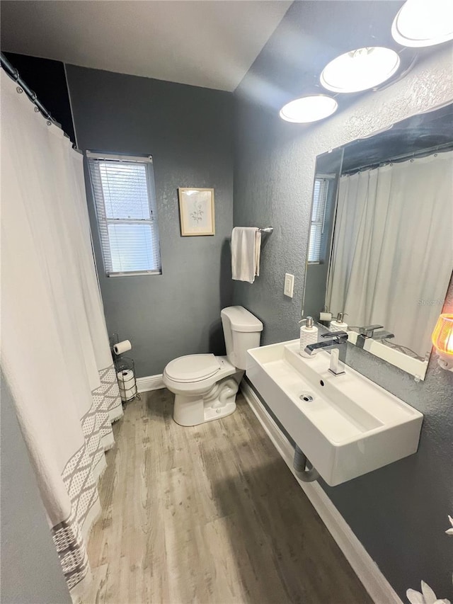 bathroom with sink, toilet, and hardwood / wood-style flooring