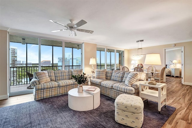 living room featuring dark hardwood / wood-style flooring, ceiling fan, plenty of natural light, and crown molding