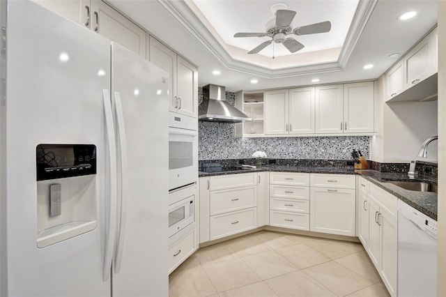 kitchen featuring sink, white cabinetry, wall chimney exhaust hood, white appliances, and a tray ceiling