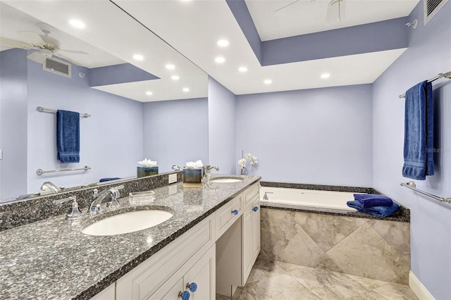 bathroom with ceiling fan, vanity, and a relaxing tiled tub