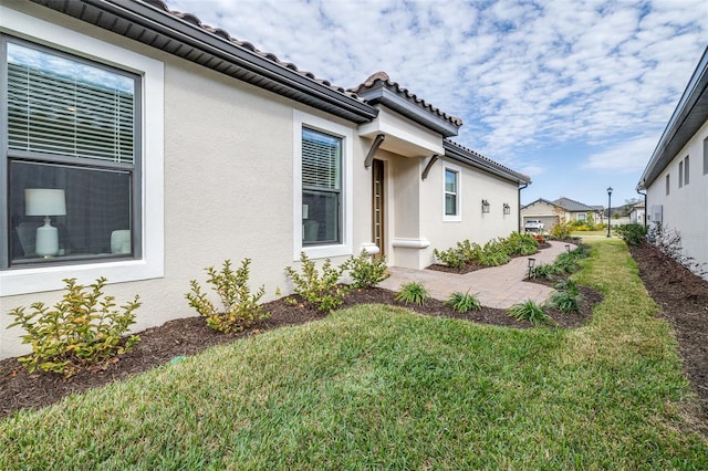 view of side of home featuring a yard and a patio