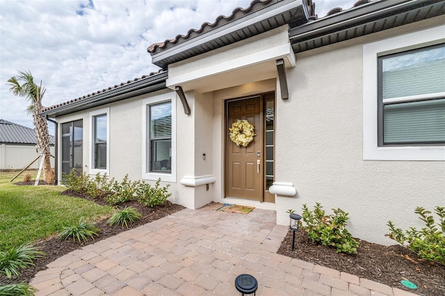 doorway to property with a patio and a lawn