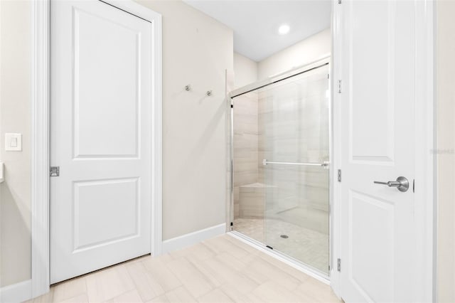 bathroom with a shower with door