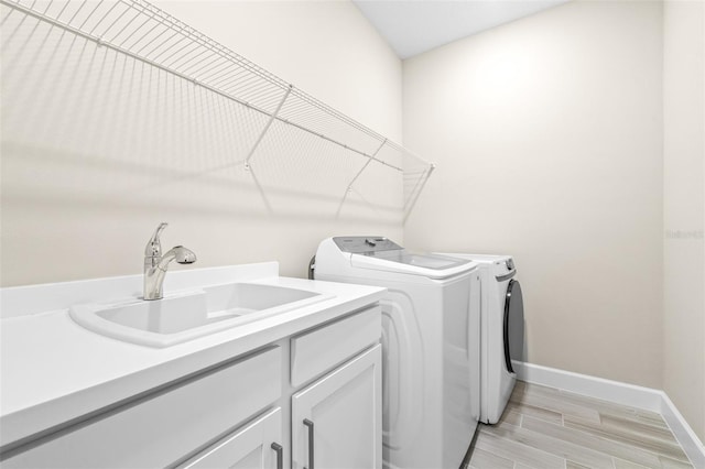 laundry room featuring sink, cabinets, and washing machine and dryer