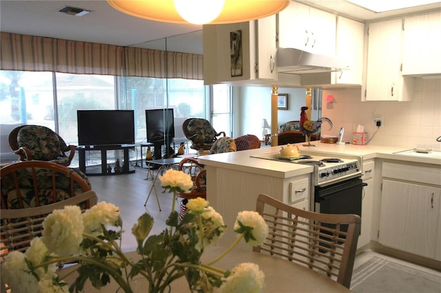 kitchen with electric stove, sink, kitchen peninsula, and tasteful backsplash