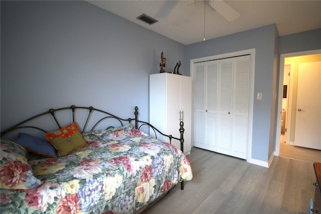 bedroom with ceiling fan, a closet, and hardwood / wood-style floors