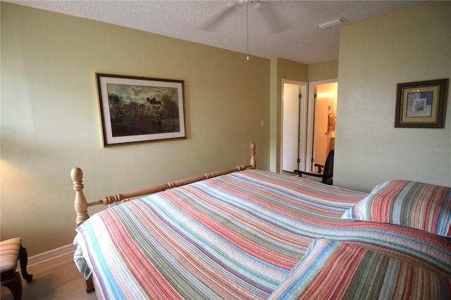 bedroom featuring ceiling fan, a textured ceiling, and hardwood / wood-style floors