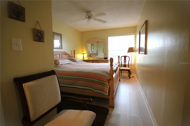 bedroom featuring a textured ceiling, ceiling fan, and light hardwood / wood-style flooring