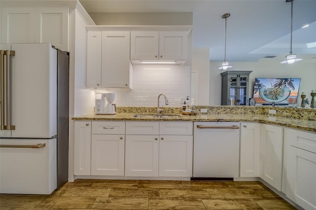 kitchen featuring sink, white appliances, pendant lighting, and white cabinets