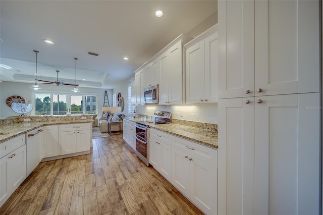 kitchen with white cabinets, stainless steel appliances, backsplash, and pendant lighting