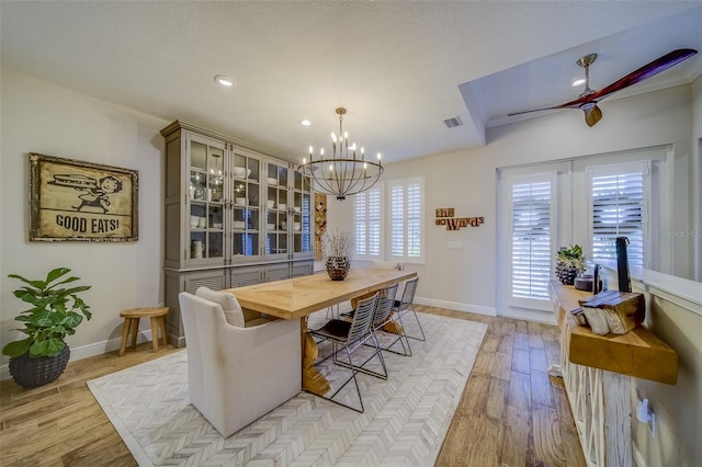 dining area featuring ceiling fan with notable chandelier, ornamental molding, and light hardwood / wood-style flooring