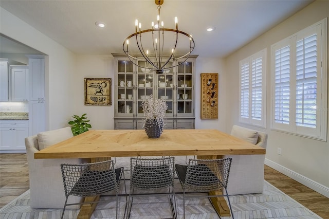 dining area with light hardwood / wood-style floors and a chandelier