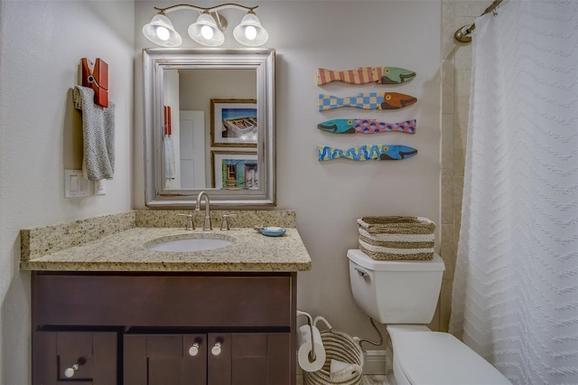 bathroom featuring toilet, vanity, and walk in shower