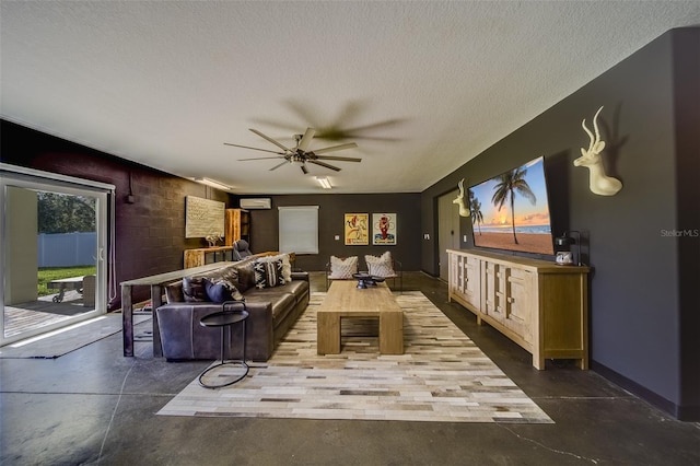 living room with ceiling fan, a textured ceiling, and concrete flooring