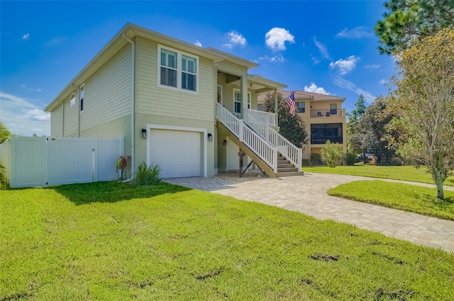 view of front of house featuring a front yard, a garage, and a porch