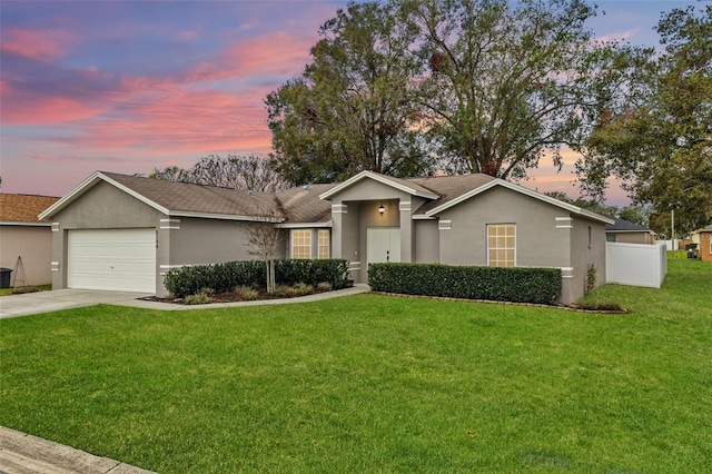 ranch-style house featuring a lawn and a garage