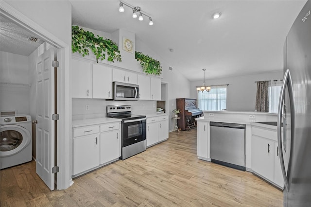 kitchen featuring washer / dryer, appliances with stainless steel finishes, pendant lighting, and white cabinetry