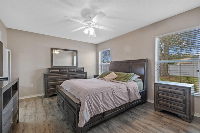 bedroom with ceiling fan, dark wood-type flooring, and a textured ceiling