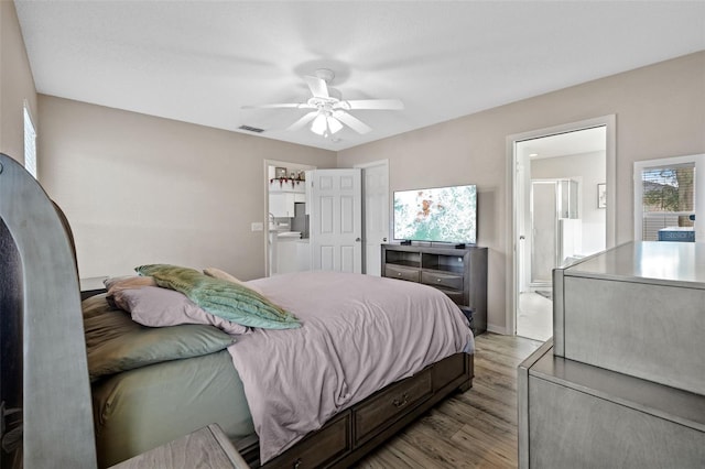 bedroom with ceiling fan, light hardwood / wood-style flooring, and connected bathroom