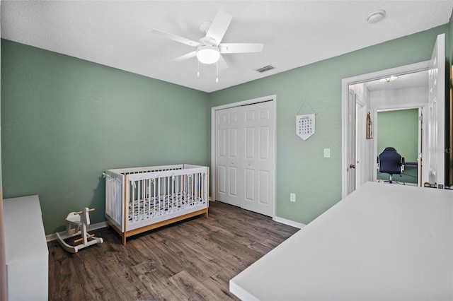 bedroom featuring ceiling fan, dark wood-type flooring, and a closet