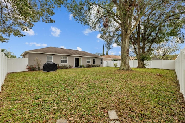 rear view of property featuring a yard