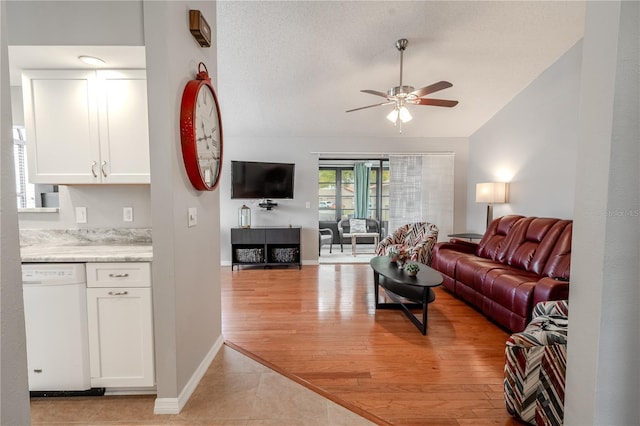 living room featuring ceiling fan, lofted ceiling, light hardwood / wood-style flooring, and a textured ceiling