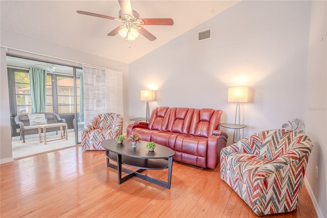 living room featuring hardwood / wood-style flooring, vaulted ceiling, and ceiling fan