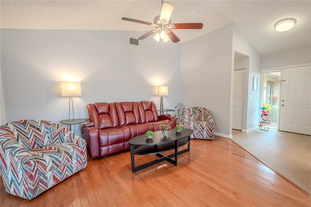 living room with lofted ceiling, hardwood / wood-style floors, and ceiling fan