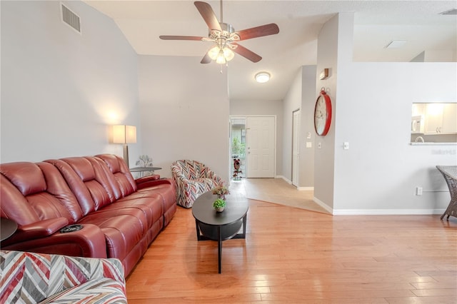 living room with lofted ceiling, light hardwood / wood-style flooring, and ceiling fan