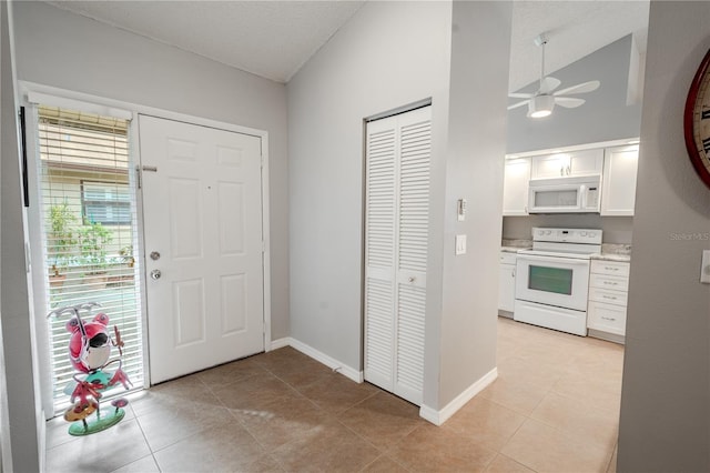 entrance foyer with light tile patterned floors, a textured ceiling, and ceiling fan