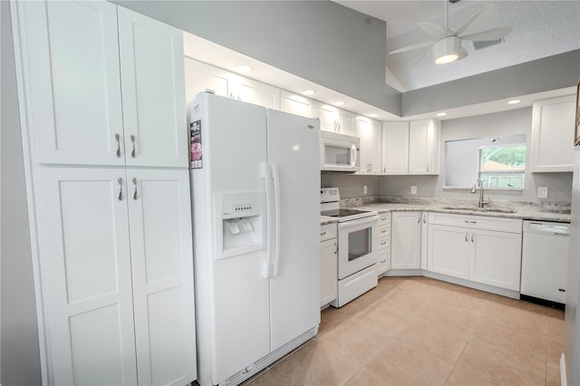 kitchen featuring vaulted ceiling, white cabinetry, sink, light tile patterned floors, and white appliances