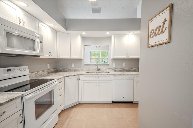 kitchen featuring sink, white cabinets, white appliances, light stone countertops, and a textured ceiling